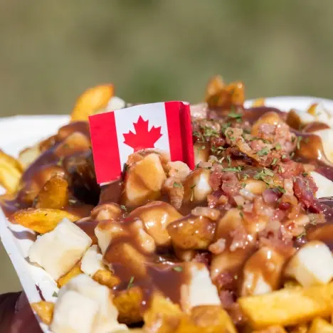 poutine with a small Canadian flag and bacon